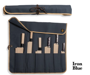 An iron-blue canvas roll holding a collection of Japanese knives.